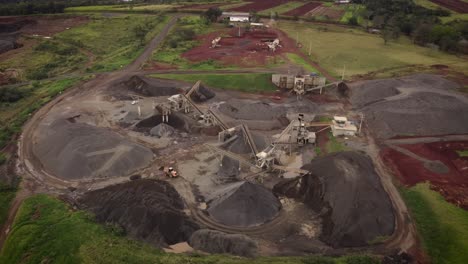 Orbit-Shot-Of-Open-Stone-Quarry,-Piles-And-Excavators-Working-Around-Near-Iguazu-River,-Brazil