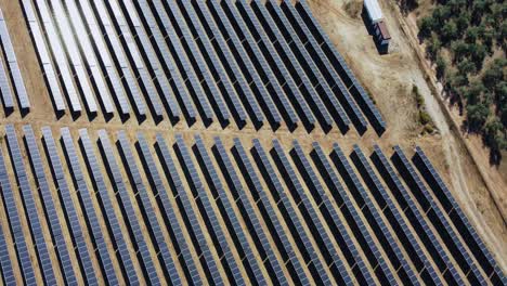 Luftaufnahme-Von-Großen-Sonnenkollektoren,-Solarenergieplanet-Durch-Olivenplantage-Auf-Dem-Land-Von-Spanien