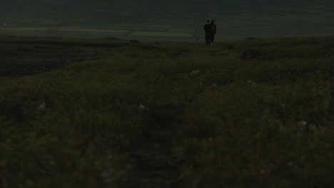 People-walking-away-from-camera-while-hiking-in-mountains-of-Iceland