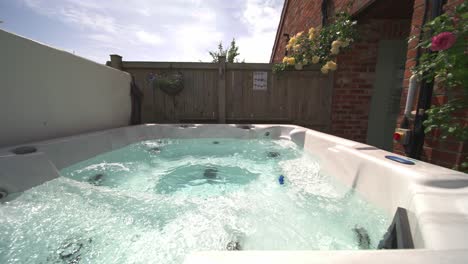 Slow-wide-side-to-side-shot-of-private-hot-tub-jacuzzi-at-vacation-rental-in-summer