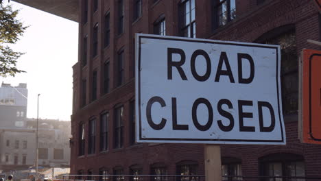 White-road-closed-sign-under-bridge,-streets-of-New-York-city,-close-up