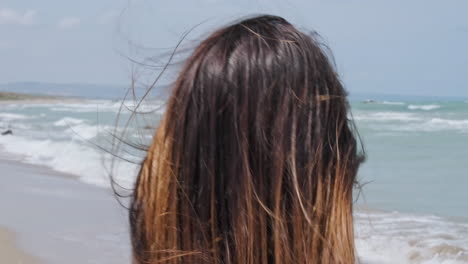 Back-View-Of-A-Woman-With-Brown-Hair-Walking-By-The-Seashore-On-Summer-Breeze