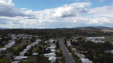 Drone-Ascendiendo-Sobre-Una-Ciudad-Rural-Australiana-Con-La-Carretera-Principal-Debajo