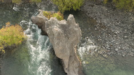Atemberaubende-Luftaufnahme,-Die-Eine-Große-Felsformation-In-Den-Weißen-Stromschnellen-Eines-Flusses-In-Argentinien-Umkreist