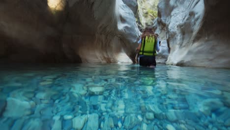 Half-Underwater-View-Of-Woman-Walking-In-Water-In-Canyon