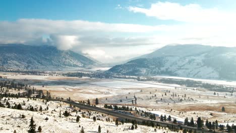 Scenic-View-of-the-Highway-5a-surrounded-by-the-Grasslands-and-mountains-of-the-Nicola-Valley-covered-in-light-snow-on-a-partly-cloudy-day-in-the-winter-with-sunshine-in-Merritt,-BC-Canada