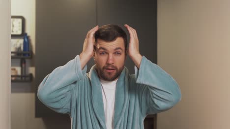 Portrait-of-a-tired-young-man-in-a-bathrobe-according-to-a-hangover-and-head-underwear