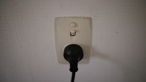 hand-switching-off-oceanic-power-point-with-black-plug-in-it