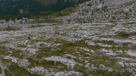 Luftaufnahme-Nach-Oben-Mit-Moos-Auf-Felsigen-Bergen-Und-Schöner-Bergkette-Im-Hintergrund---Italienische-Dolomiten-An-Sonnigen-Tagen