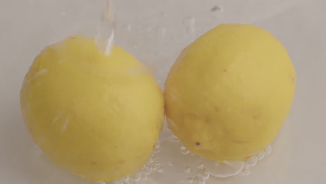 Wassertropfen-Fließen-In-Zeitlupe-Zu-Gelben-Zitronen-Hinab