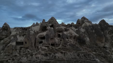 Historische-Steinhöhlen-Gegen-Bewölkten-Himmel-In-Kappadokien,-Türkei