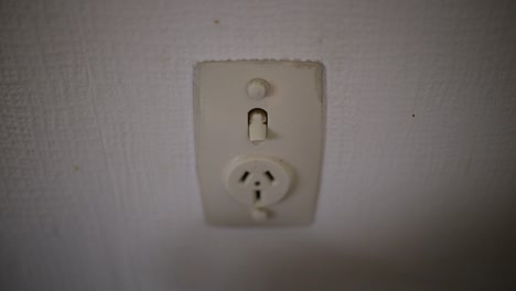 Caucasian-hand-unplugging-white-plug-then-turning-off-power-point-switch