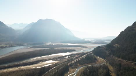 Wide-aerial-shot-of-the-Fraser-River-in-the-Lower-Mainland-in-British-Columbia-in-Canada,-bright-scene-with-foggy-mountains-in-the-autumn