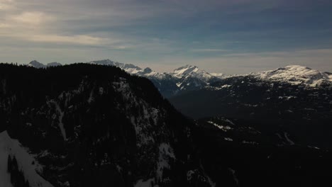 Epic-Backwards-Reveal-Shot-of-Garibaldi-Provincial-Park-with-the-snow-capped-Coast-Mountains-in-the-background,-close-to-Squamish-BC-in-Canada-in-the-winter-month