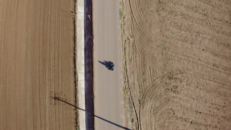 Top-Down-Aerial-View-of-Motorcycle-Rider-in-Empty-Countryside-Road,-High-Angle-Drone-SHot