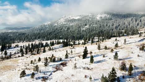 Grassland-and-forest-mountains-of-the-Nicola-Valley-covered-in-light-snow-on-a-partly-cloudy-day-in-the-winter-with-sunshine-close-to-Merritt,-BC-Canada