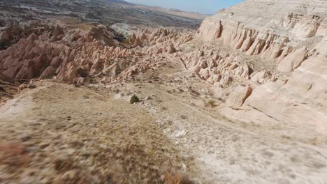 Vuela-Sobre-Un-Paisaje-árido-Con-Formaciones-Rocosas-Y-Acantilados-En-La-Región-De-Capadocia,-Turquía-Central