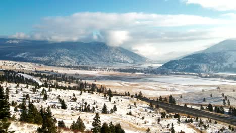 Cinematic-Scene-of-the-Highway-5a-surrounded-by-Trees,Grassland-mountains-of-the-Nicola-Valley-in-winter,-snow-covered-landscape-with-sunshine-close-to-Merritt,-BC-Canada