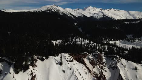 Extraordinary-Scene-of-the-Panorama-Ridge-of-Garibaldi-Provincial-Park-in-the-winter,-backwards-flight-over-evergreen-forests-and-rocky-cliffs