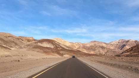 Fahrt-Durch-Die-Berglandschaft-Im-Death-Valley-Nationalpark-Mit-Leichten-Wolken-Und-Bunten-Bergen