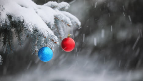 Rote-Und-Blaue-Weihnachtskugeln-Hängen-An-Einer-Kiefer,-Während-Es-Schneit