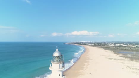 Descending-aerial-view-over-iconic-Trafalgar-lighthouse-on-the-beach-in-Spain