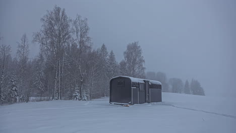 Hut-shrouded-in-morning-mist-of-snowy-landscape-in-Latvia,-Timelapse