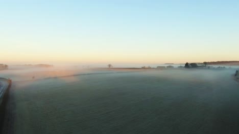 Drone-reveal-of-low-hanging-fog-over-british-countryside-in-yorkshire-on-frosty-morning-at-sunrise