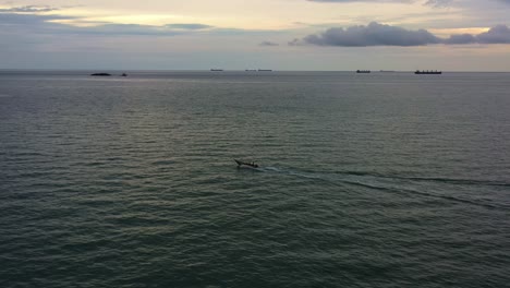 Toma-Aérea-De-Drones-Capturando-Un-Pequeño-Barco-De-Pesca-Tradicional-Navegando-En-El-Mar