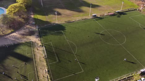 Gente-Practicando-Tiros-En-La-Portería-De-Fútbol-En-La-Cancha-Verde-De-Fútbol,-Campo-De-Hierba