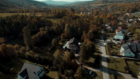 Drone-shot-of-single-family-house-surrounded-by-forest-in-fall-season