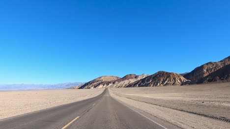 Driving-Death-Valley-National-Park-at-High-Speed-near-Colorful-Mountains