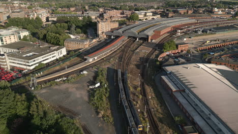 Panning-Aerial-Drone-Shot-of-York-Railway-Station-with-2-Trains-Leaving-and-Entering-the-Station-with-National-Railway-Museum-and-River-Ouse-in-View---North-Yorkshire-United-Kingdom