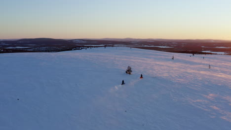 Paar-Schneemobilfahrer,-Die-Bei-Sonnenaufgang-über-Norbotten,-Die-Schwedische-Schneebedeckte-Landschaft,-Rasen