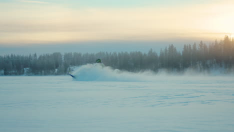 Energetic-snowmobile-driver-speeding-across-snowy-Lapland-woodland-at-sunrise