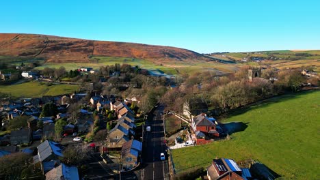 Aerial-drone-video-footage-of-the-small-rural-village-of-Denshaw,-a-typical-rural-village-in-the-heart-of-the-Pennine-hills