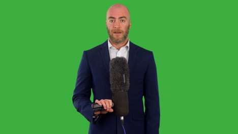 A-male-newspresenter-with-a-microphone-presenting-news-on-the-television-with-green-screen-background