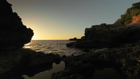 Filmischer-Schiebeschuss-Schöner-Felsiger-Strand-Bei-Sonnenuntergang-An-Der-Küste-Von-Ibiza