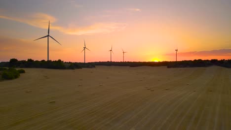 Luftbild-Windmühlen-Silhouetten-Windkraftanlagen-Im-Feld-Hintergrundbeleuchtung-Mit-Warmem-Sonnenlicht-Bei-Sonnenuntergang-Oder-Sonnenaufgang