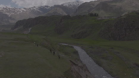 Establishing-shot-of-hikers-looking-down-onto-a-river-running-between-the-mountains