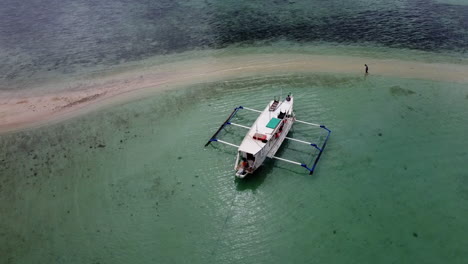 Orbit-Shot-Of-Anchored-Boat-On-Sand-Bar