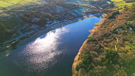 Winter-aerial-footage-scene-of-Scammonden-Reservoir-with-shimmering-sunlight-reflacting-on-the-surface