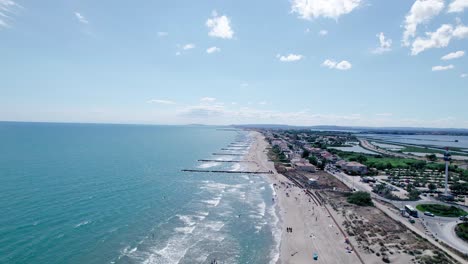 Aerial-trucking-shot-of-Sandy-beach-with-Jetty-and-Blue-French-Riviera-in-La-Grande-Motte---wide-shot
