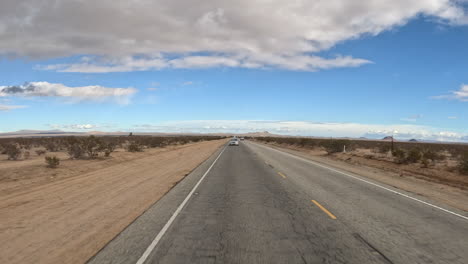Looking-out-the-rear-window-while-driving-through-the-Mojave-Desert,-California---hyper-lapse