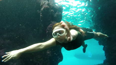 Junges-Mädchen,-Das-Unter-Klarem-Blauem-Wasser-Schwimmt-Und-Das-Tiefe-Mysteriöse-Meer-Erkundet