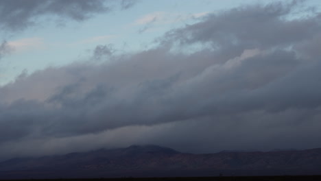 Storm-cloud-blowing-in-the-wind-over-the-mountains-at-sunrise---cloudscape-time-lapse