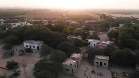 Aerial-Parallax-Shot-View-Of-Rural-Village-In-Sindh-With-Sunset-On-Horizon