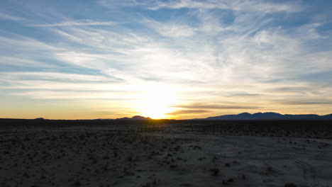 Schneller-Hyperlapse-Aus-Der-Luft-über-Die-Silhouette-Der-Mojave-Wüste-Während-Eines-Goldenen-Sonnenuntergangs-Mit-Einer-Feinen-Wolkenlandschaft