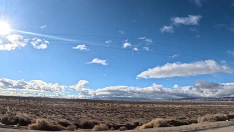 Fahrt-Durch-Die-Mojave-Wüste-Auf-Einem-Highway-In-Südkalifornien,-Vorbei-An-Strommasten-Und-Schroffem-Gelände---Aus-Der-Perspektive-Des-Beifahrerfensters,-Hyperlapse