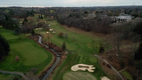 Aerial-drone-establishing-shot-of-an-empty-green-golf-course-in-Toronto,-Ontario,-Canada